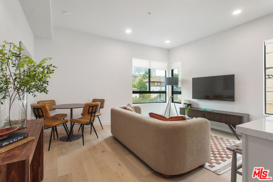 10310 Santa Monica Boulevard, Unit 216 Los Angeles, CA 90025 - Photo 8 of 38 a living room with furniture and a flat screen tv