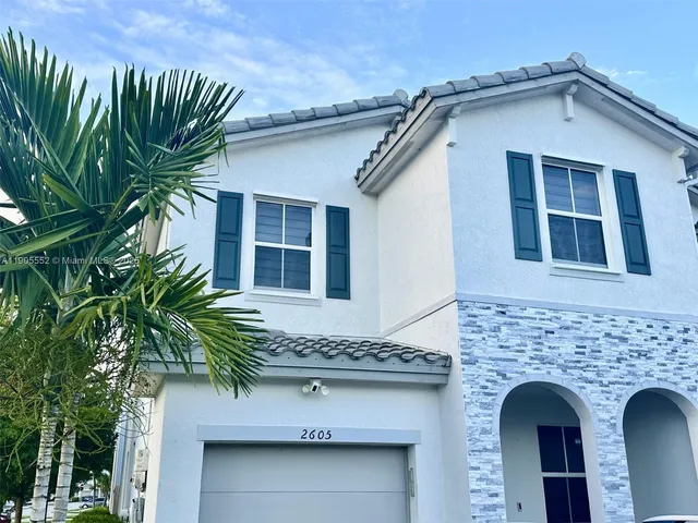 a front view of a house with plants