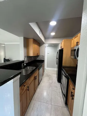 a kitchen with stainless steel appliances granite countertop a refrigerator a sink a stove and dishwasher