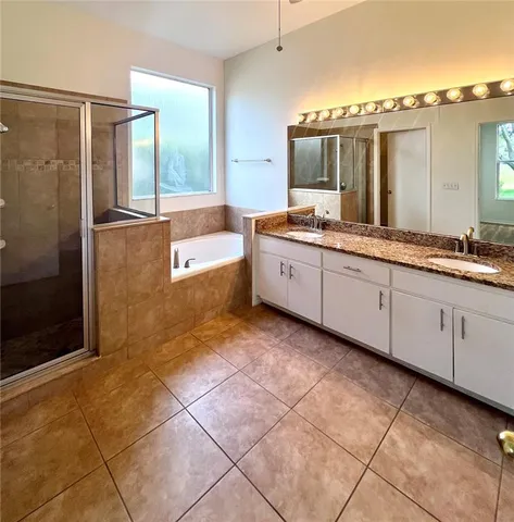 a bathroom with a granite countertop sink a mirror and a bathtub