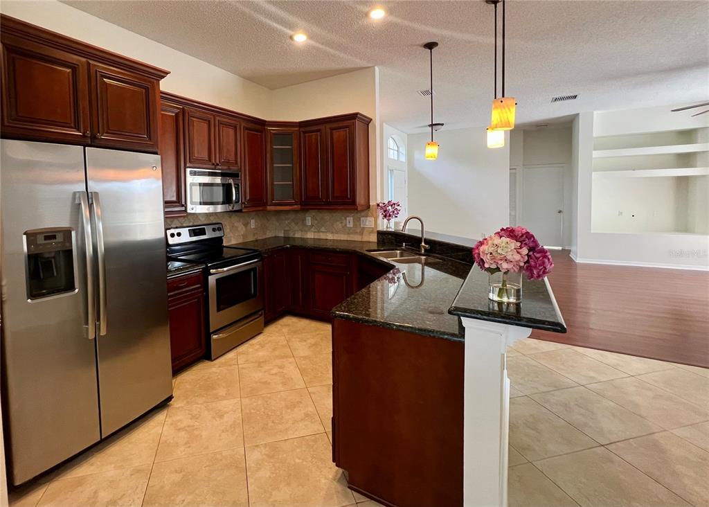3515 Fox Squirrel Lane Valrico, FL 33596 - Photo 7 of 24 a kitchen with stainless steel appliances granite countertop a sink stove and refrigerator