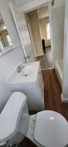 a bathroom with a toilet mirror and vanity