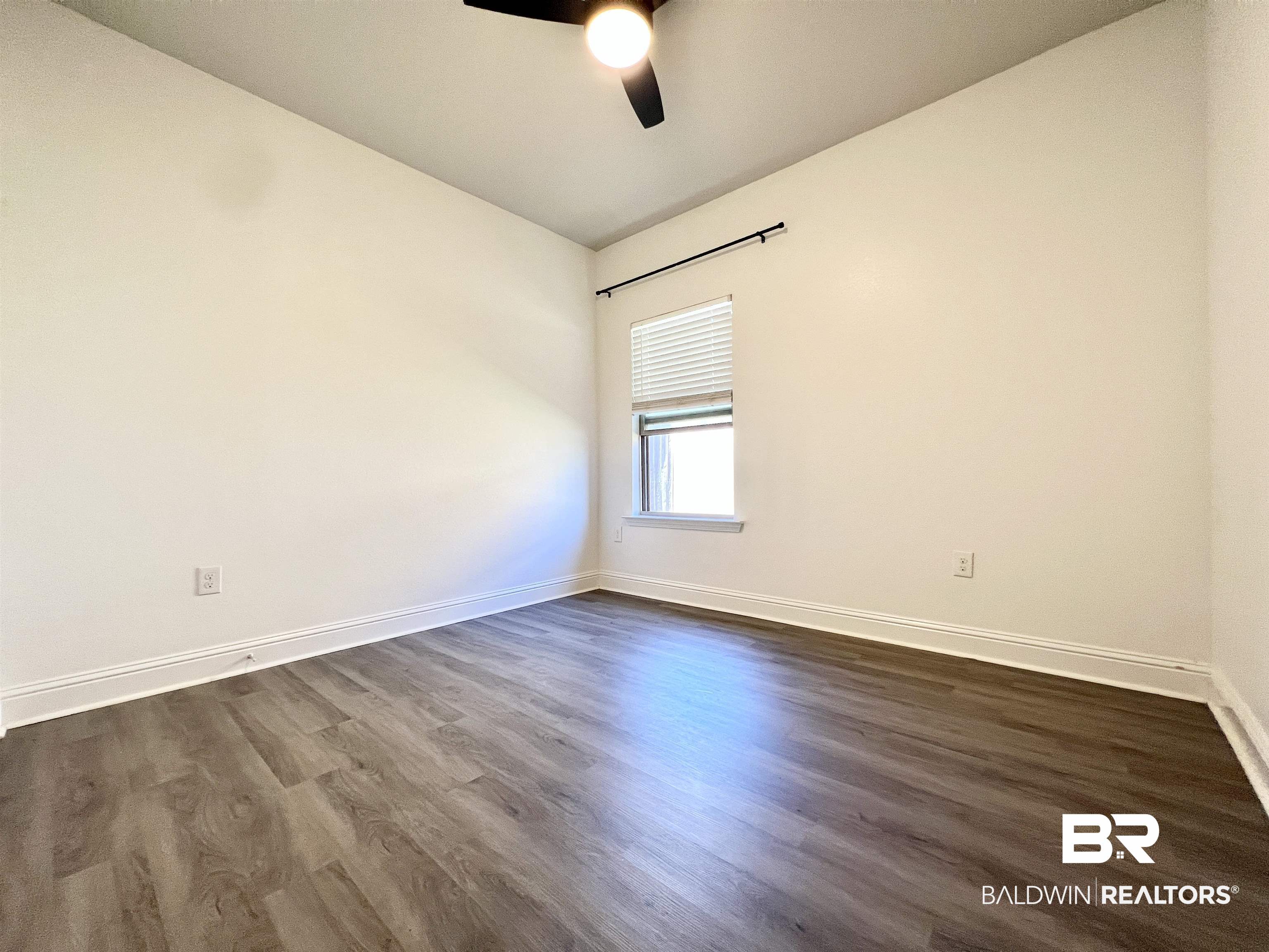 24785 Slater Mill Road Daphne, AL 36526 - Photo 15 of 46 Spare room with dark wood-type flooring, vaulted ceiling, and ceiling fan