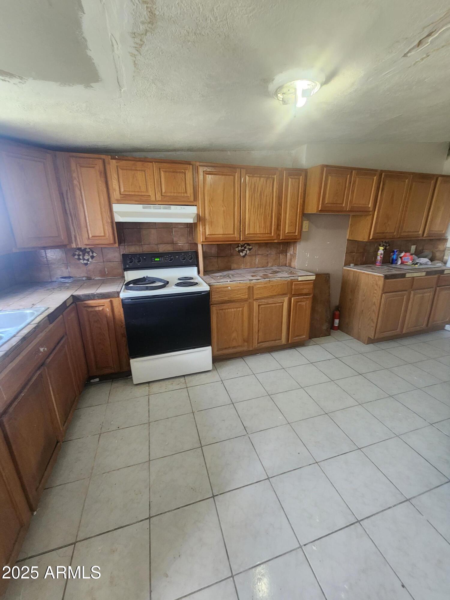 730 1st Street Douglas, AZ 85607 - Photo 11 of 13 a kitchen with a sink a stove and cabinets