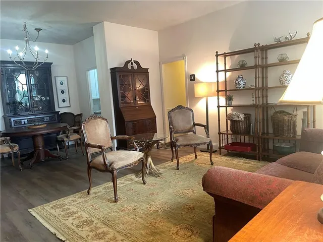 a living room with furniture a lamp paintings and a table