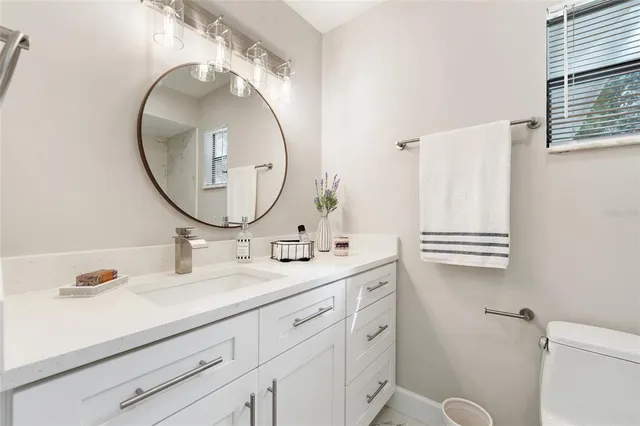 a bathroom with a sink mirror and toilet