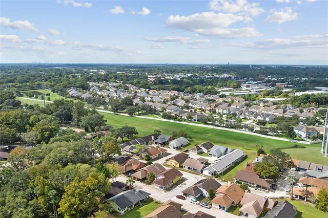 an aerial view of a city with lots of residential buildings and mountain view in back
