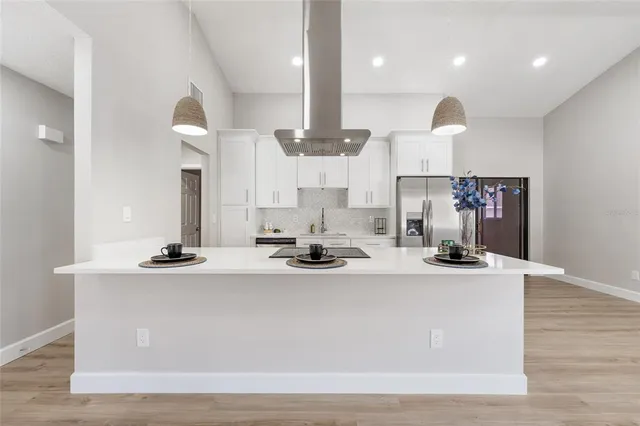a view of kitchen with kitchen island stainless steel appliances a sink and living room view