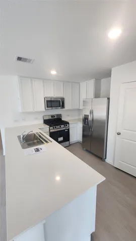 a kitchen with stainless steel appliances a refrigerator stove microwave and sink