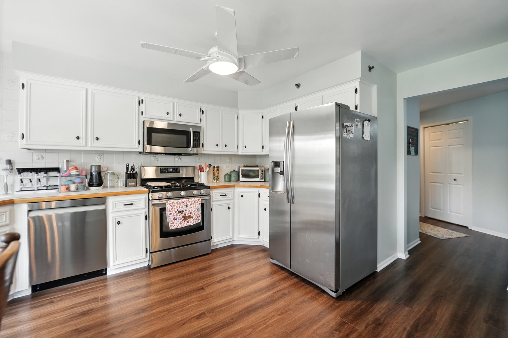 10228 SW Highway, Unit 3C Chicago Ridge, IL 60415 - Photo 3 of 17 a kitchen with stainless steel appliances a refrigerator a stove top oven and wooden floors