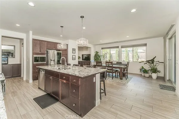 a kitchen with kitchen island granite countertop a sink cabinets and stainless steel appliances