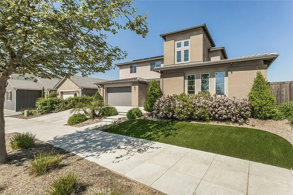 a front view of a house with a garden and yard