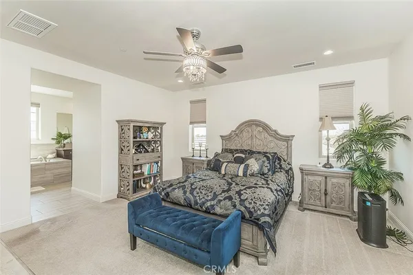 a spacious bedroom with a bed and a chandelier