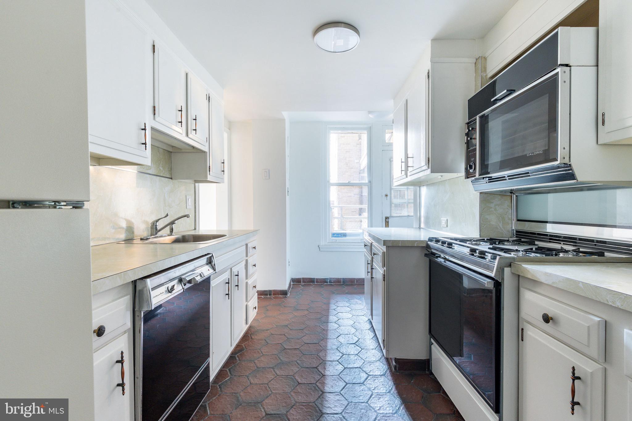 1901 Walnut Street, Unit 5E Philadelphia, PA 19103 - Photo 18 of 28 a kitchen with stainless steel appliances granite countertop a stove a sink and a microwave