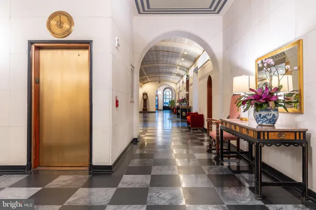a lobby with a table and a chandelier