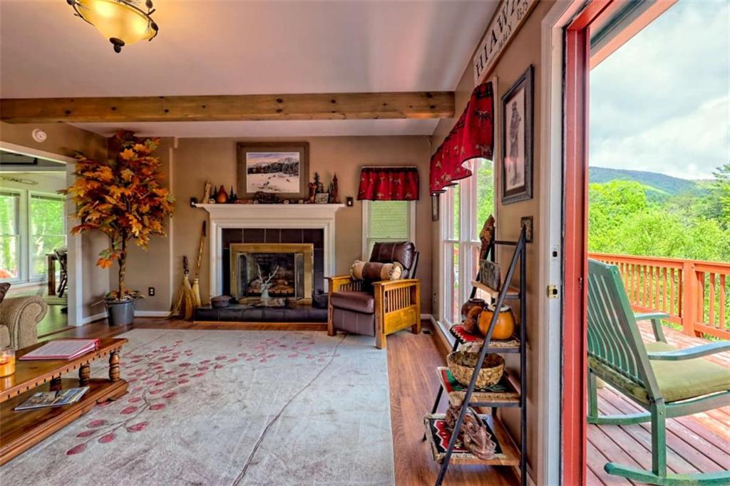 995 Glassy Mountain Road Hiawassee, GA 30546 - Photo 15 of 87 a living room with furniture a fireplace and a large window