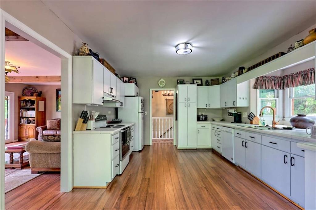 995 Glassy Mountain Road Hiawassee, GA 30546 - Photo 22 of 87 a kitchen with cabinets a sink and wooden floor