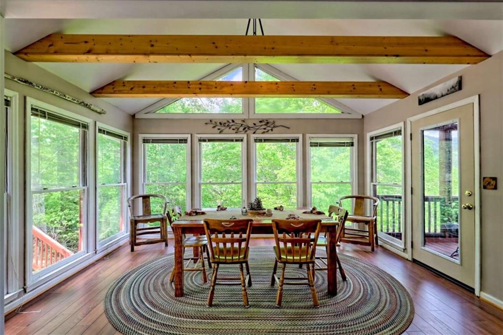 995 Glassy Mountain Road Hiawassee, GA 30546 - Photo 27 of 87 a dining room with furniture a chandelier and wooden floor