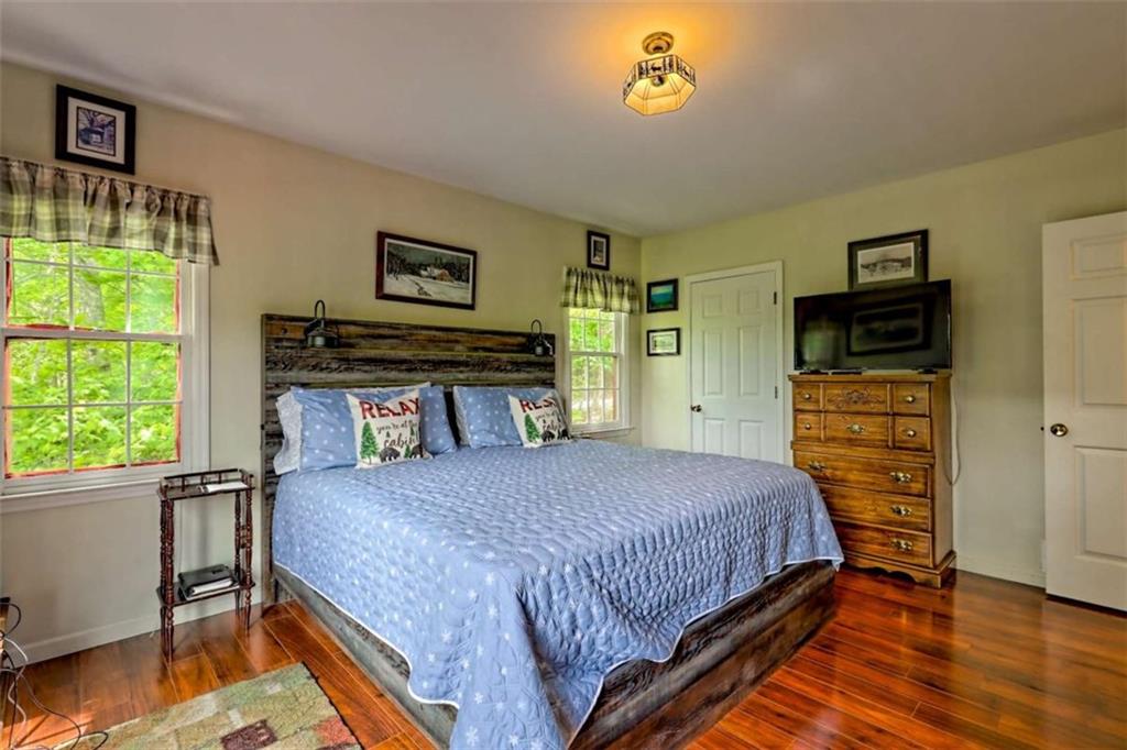 995 Glassy Mountain Road Hiawassee, GA 30546 - Photo 40 of 87 a bedroom with a bed and a tv on the dresser