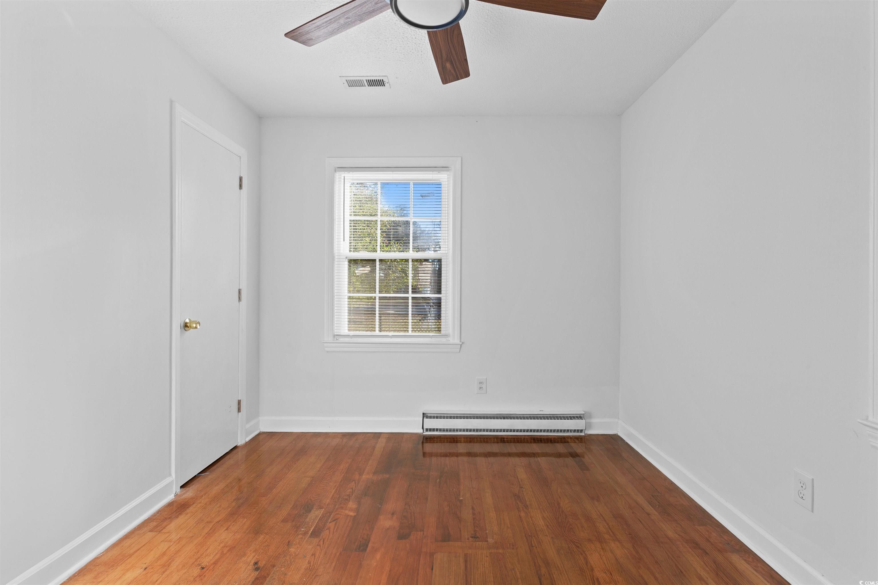 139 State Rd S-22-496 Andrews, SC 29510 - Photo 15 of 20 Empty room with dark wood-type flooring, a baseboard radiator, and ceiling fan