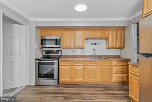 a kitchen with stainless steel appliances granite countertop a sink and a stove
