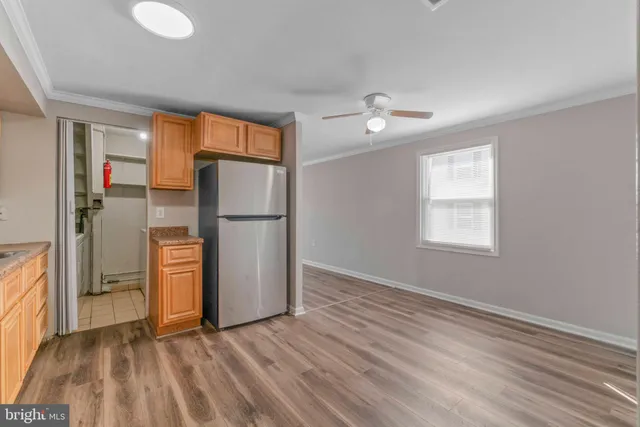 an empty room with a window and a refrigerator