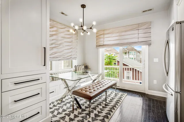 a dining room with furniture a chandelier and wooden floor