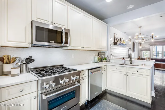 a kitchen with stainless steel appliances granite countertop a sink stove and microwave