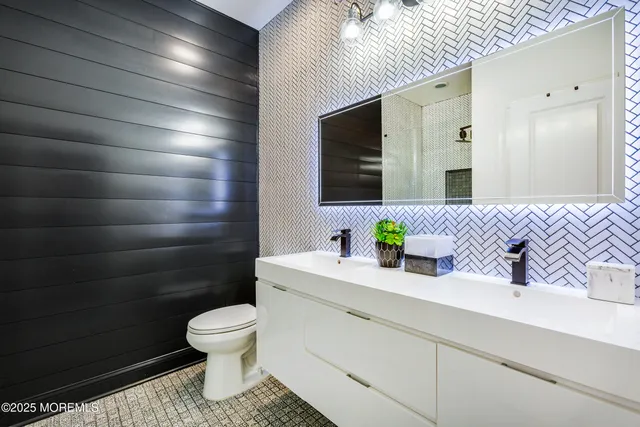 a bathroom with a sink a toilet and mirror