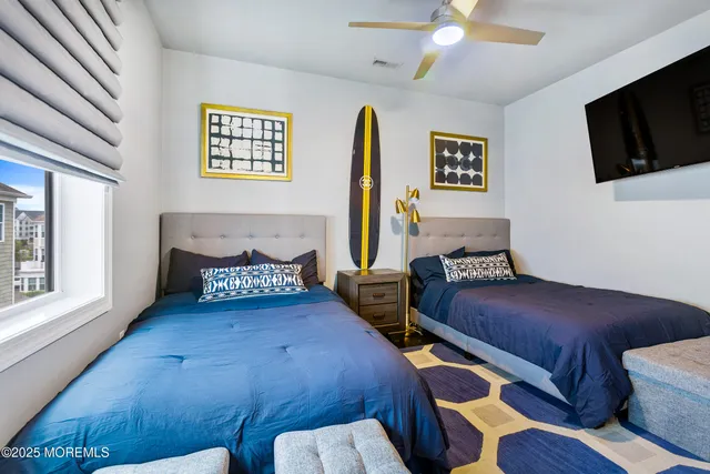 a bedroom with two beds and a flat screen tv