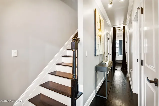 a view of a hallway with wooden floor and staircase