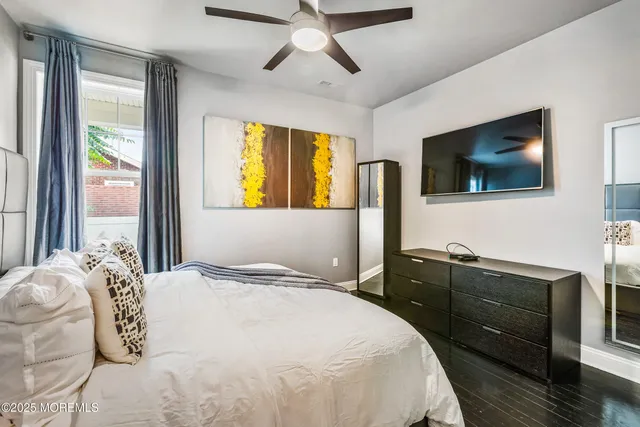 a bedroom with a bed and a flat tv screen on dresser