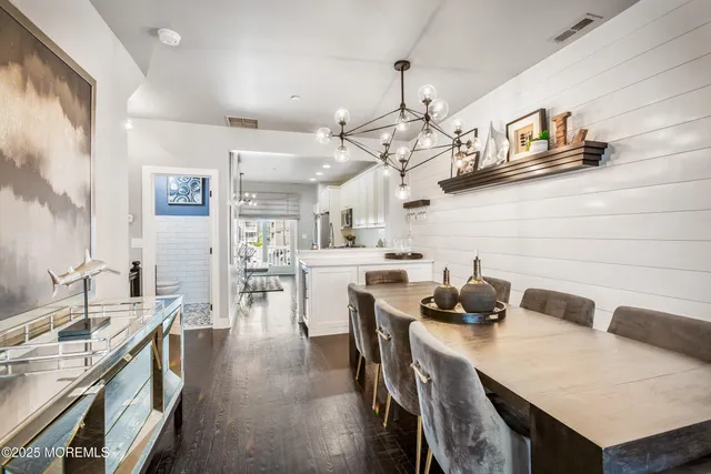 a open kitchen with cabinets a sink dishwasher a dining table and chairs with wooden floor