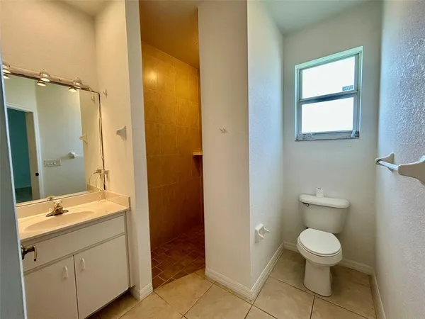 a bathroom with a granite countertop toilet a sink and a mirror