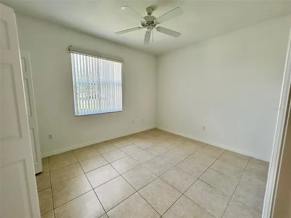 an empty room with windows and fan