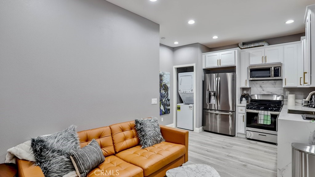 408 South Flower Street Santa Ana, CA 92703 - Photo 45 of 71 a kitchen with stainless steel appliances kitchen island granite countertop a refrigerator a stove a oven and white cabinets with wooden floor