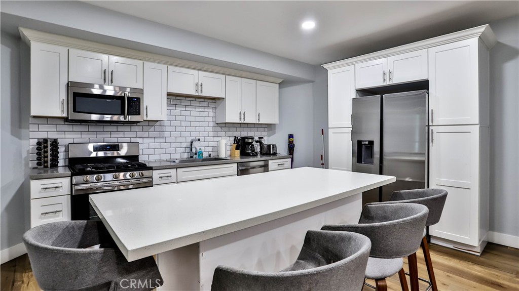 408 South Flower Street Santa Ana, CA 92703 - Photo 8 of 71 a kitchen with stainless steel appliances granite countertop a sink a stove a microwave a refrigerator a stove and white cabinets