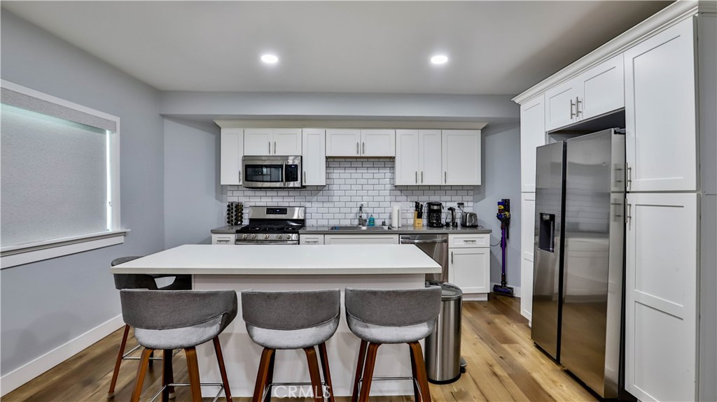 408 South Flower Street Santa Ana, CA 92703 - Photo 9 of 71 a kitchen with granite countertop a refrigerator a sink a stove a dining table and chairs