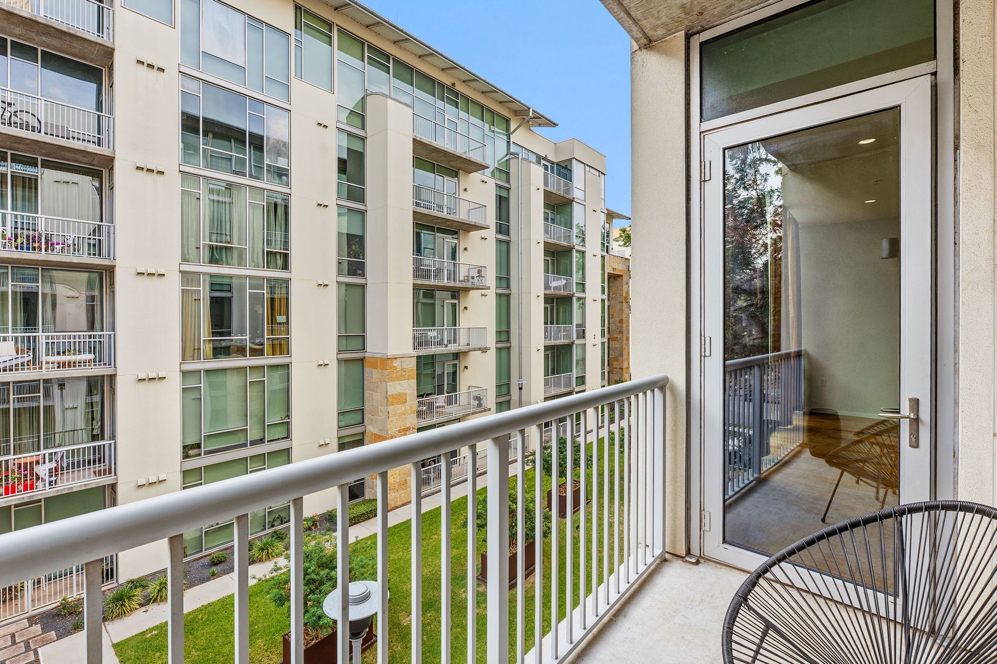 1600 Barton Springs Road, Unit 1302 Austin, TX 78704 - Photo 6 of 15 A private balcony offers concrete flooring and metal railings overlooking a landscaped interior courtyard.