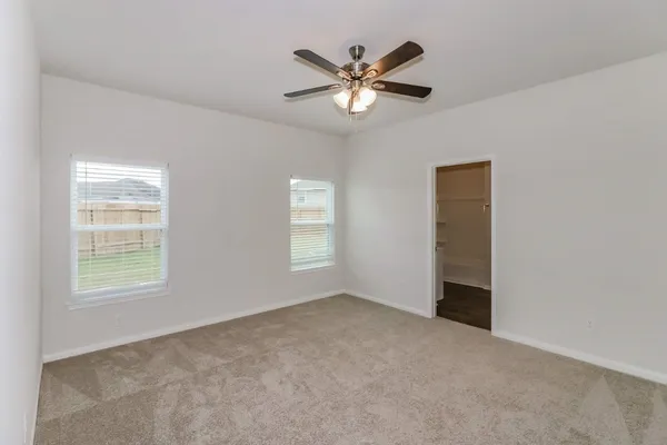 an empty room with closet and ceiling fan