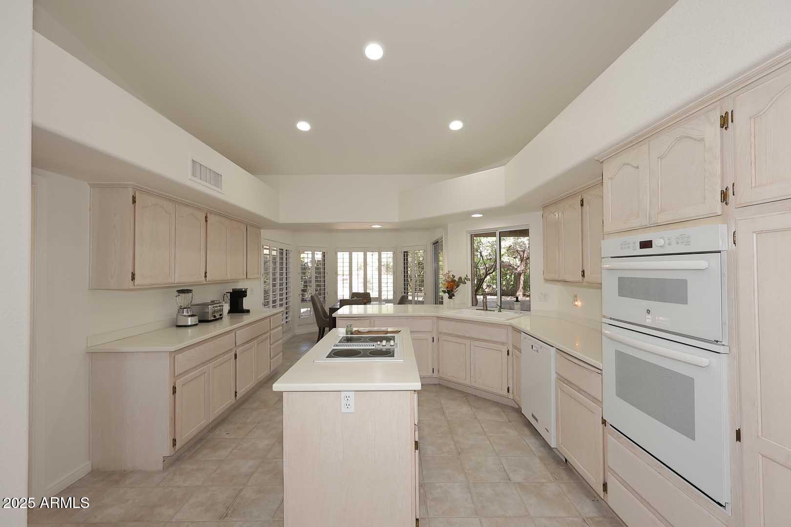 18510 East Leather Lane Rio Verde, AZ 85263 - Photo 15 of 67 a kitchen that has a lot of white cabinets and stainless steel appliances
