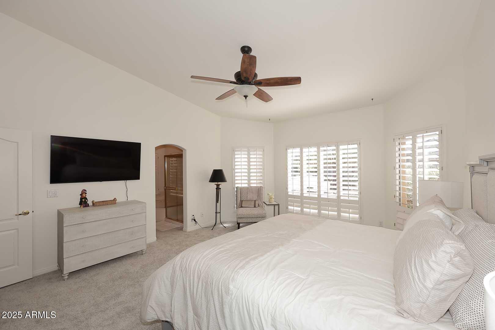 18510 East Leather Lane Rio Verde, AZ 85263 - Photo 27 of 67 a bedroom with a bed a flat screen tv and a couch