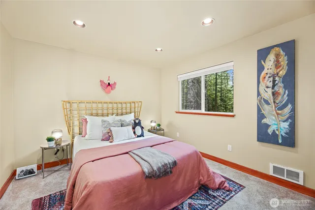 a spacious bedroom with wooden floor and windows