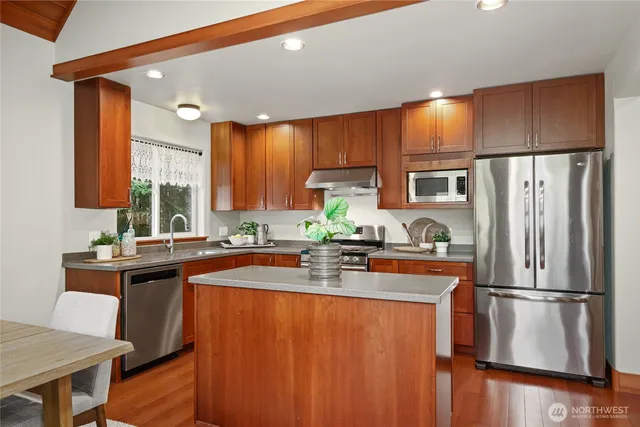 a kitchen with stainless steel appliances a stove a sink a stove and cabinets