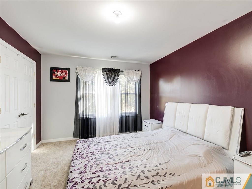 110 Cottrell Road Old Bridge, NJ 07747 - Photo 21 of 25 a bedroom with a large bed and a chandelier