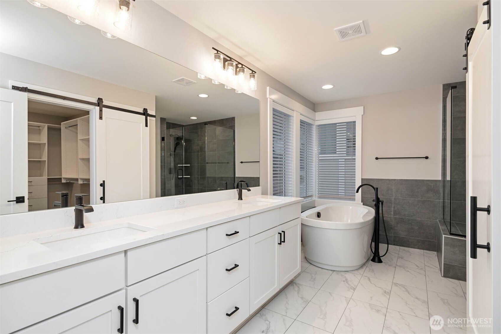 7560 South 130th Place Seattle, WA 98178 - Photo 10 of 27 a bathroom with a double vanity sink a mirror and a bathtub