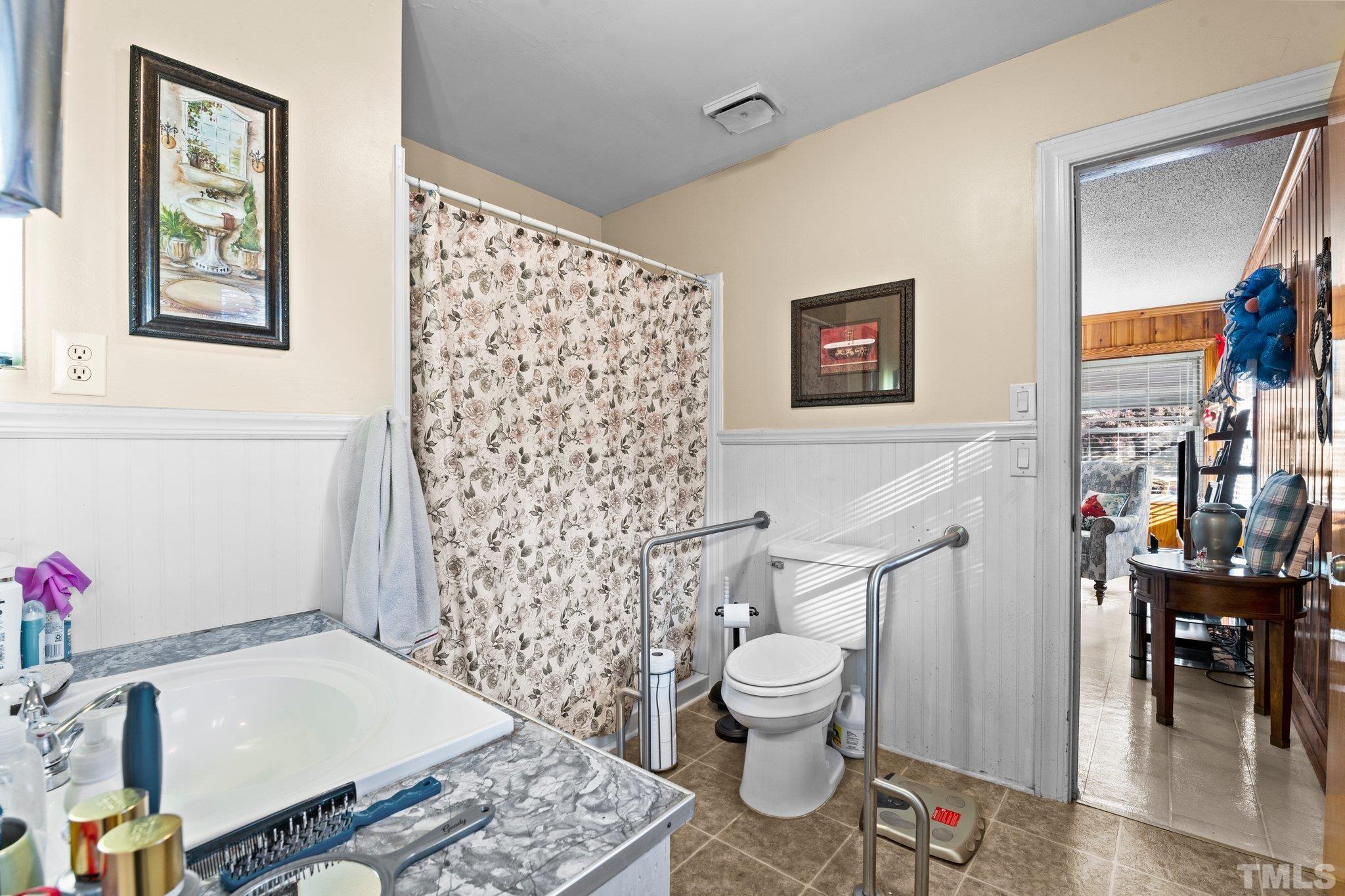450 Younger Road Roxboro, NC 27573 - Photo 36 of 43 a bathroom with a toilet and a shower curtain