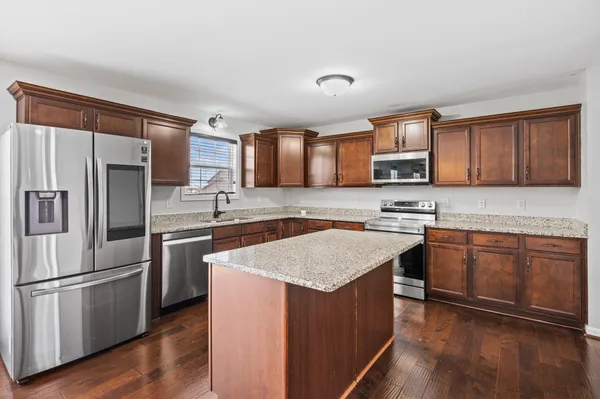 a kitchen with stainless steel appliances granite countertop a refrigerator stove microwave and sink