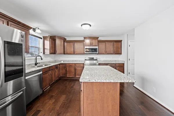a kitchen with stainless steel appliances granite countertop a sink stove and refrigerator