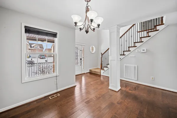 a view of entryway and hall with wooden floor